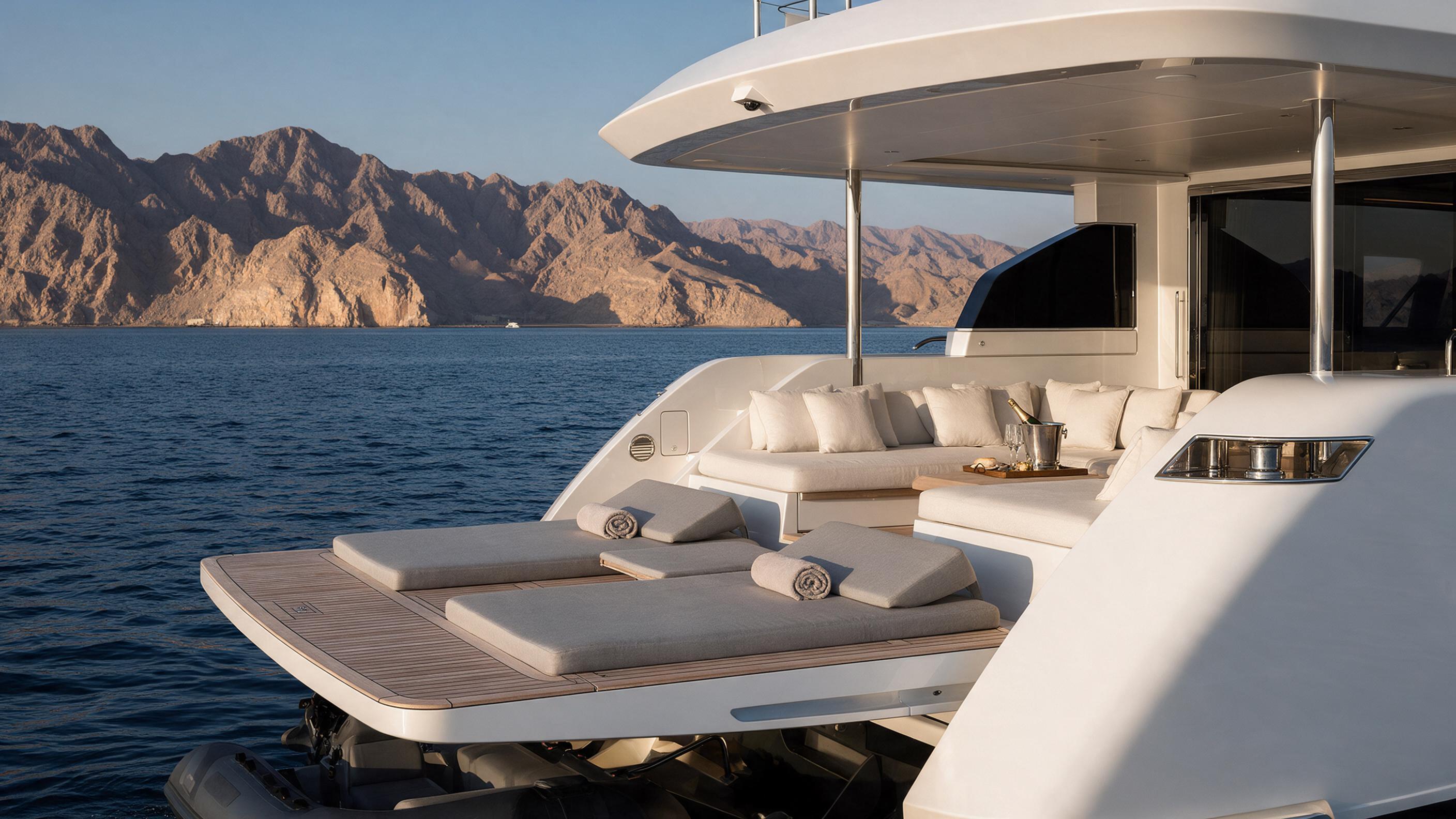 Aft deck lounge facing the open horizon aboard white-hull Aurora